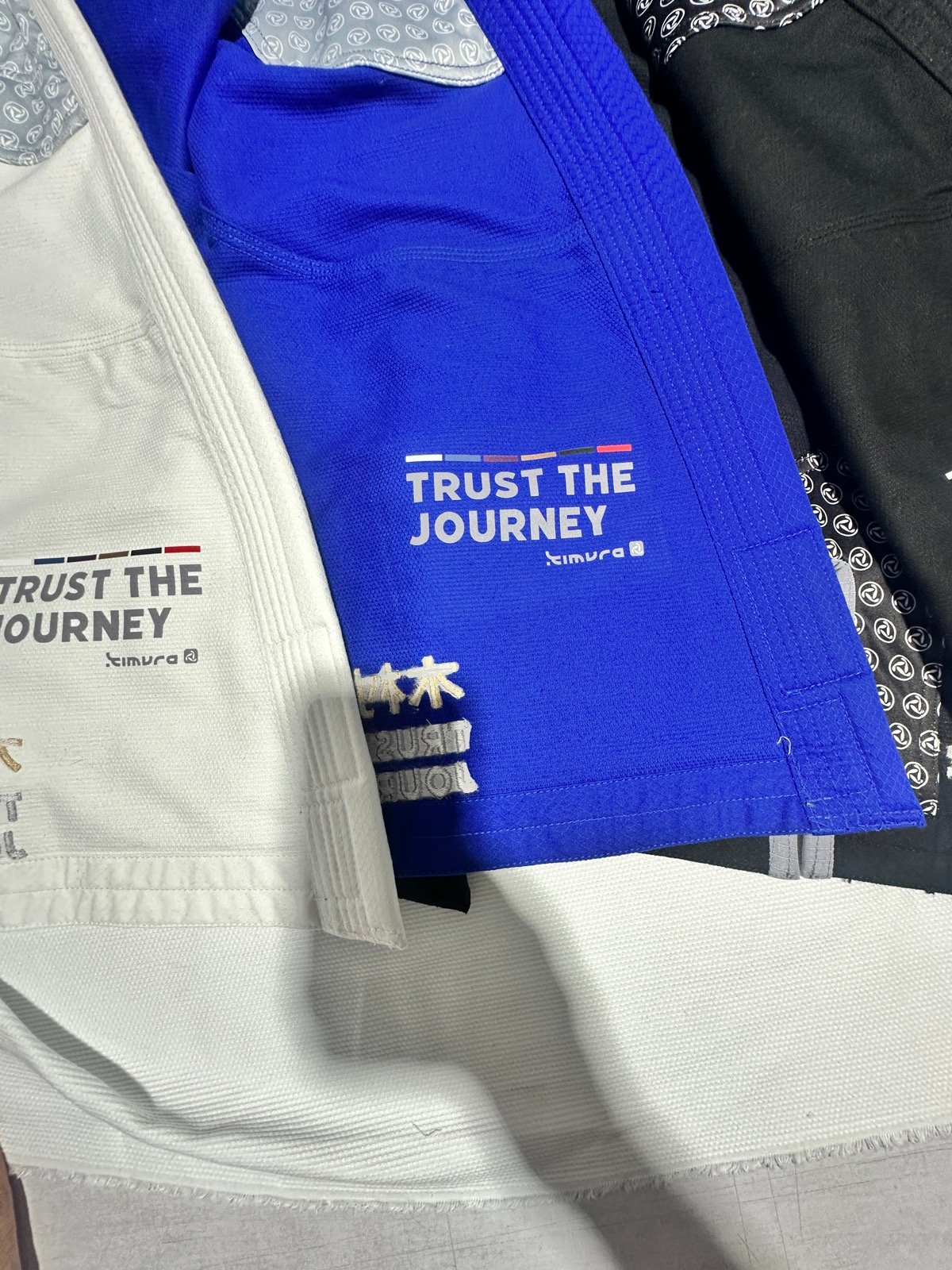 Brazilian jiu-jitsu gis in white, blue and black with custom branding woven in